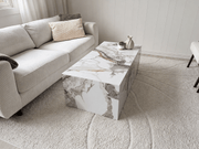 Sofabord i marmor imitasjon plassert i en lys stue med beige sofa og stilige dekorasjoner.