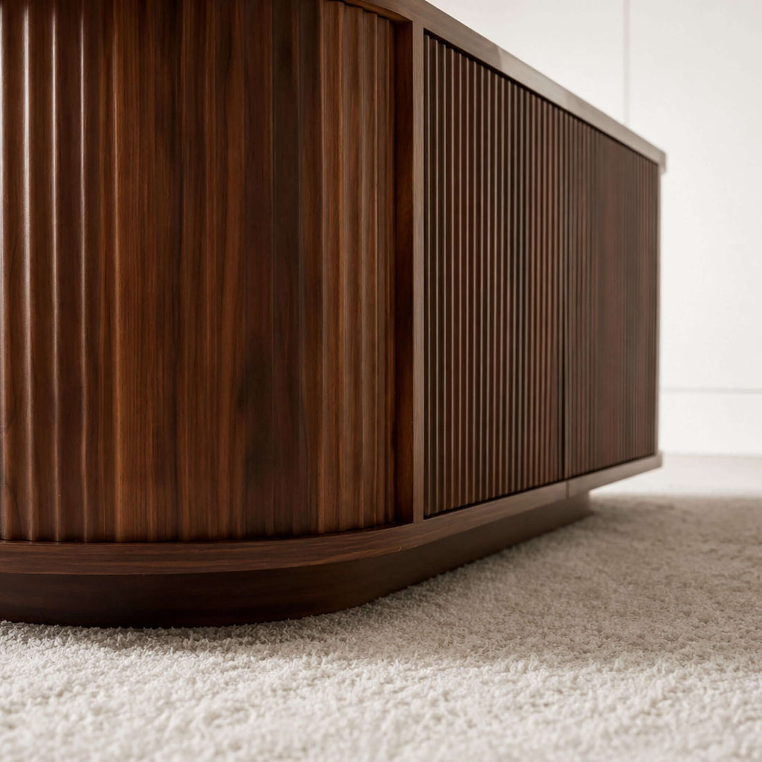 Ovalt Salongbord with a rich walnut finish, showcasing modern design and elegant ribbed texture.